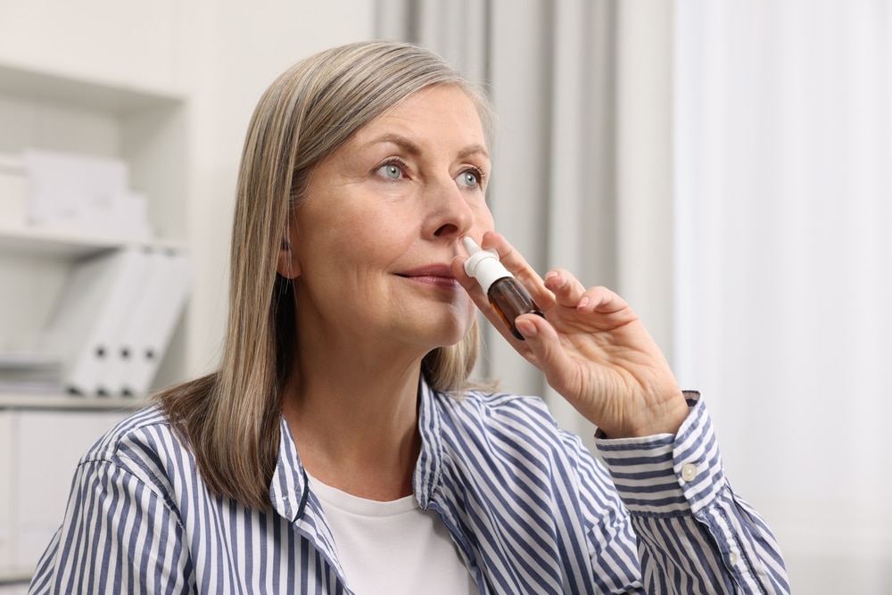 Woman using medication for her chronic rhinitis