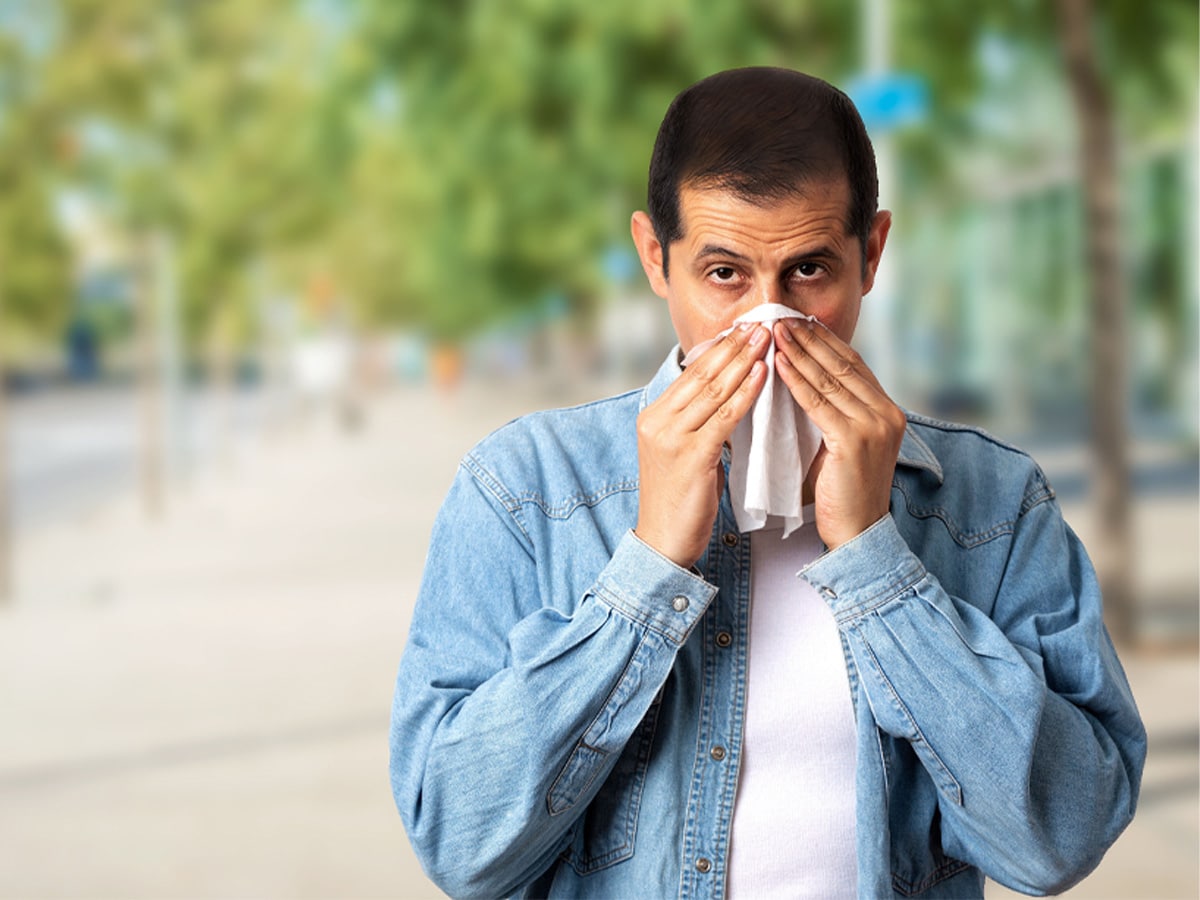 Man sneezing into a tissue